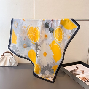 Détail d'un foulard en soie à imprimé citron et marguerites dans un décor lumineux