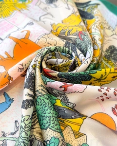 Detailed close-up of silk square scarf featuring vibrant animal and nature illustrations