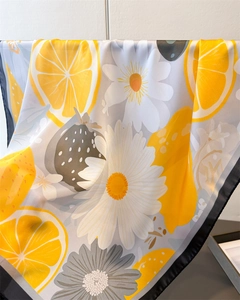 Vue détaillée d'imprimé citron et marguerite sur foulard en soie avec bordure noire