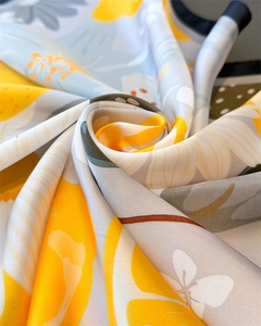 Vue détaillée du foulard en soie à imprimé citron montrant la texture lisse du tissu
