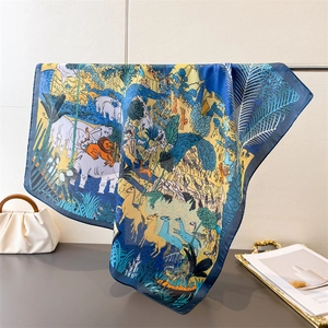 Detail of printed silk scarf showing jungle animals, lush tropical plants and satin texture