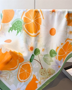 Détail d'un foulard en soie à imprimé floral citron avec tranches d'orange