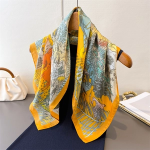 Elegant silk scarf featuring horse and nature prints in orange and green with wooden hanger