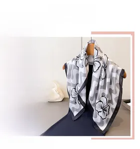 Gros plan d'un foulard en soie élégant avec imprimé floral noir et blanc et vagues