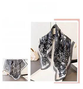 Detail of vintage black and white floral silk scarf with tropical pattern and striped border