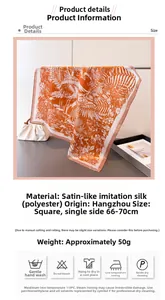 Detail view of square satin floral scarf with vibrant orange and white plant patterns