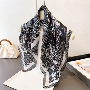 Elegant black and white floral print silk satin scarf on hanger with striped borders