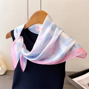 Détail d'un foulard en soie à imprimé floral aux textures ondulées bleu et rose