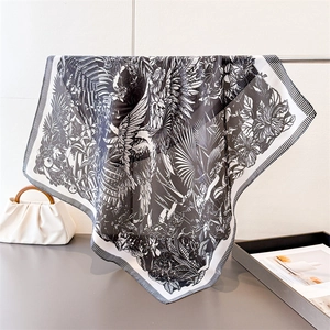 Detail of silk-like scarf with tropical floral prints and black and white striped border