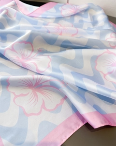 Vue détaillée d'un foulard en soie avec vagues bleues élégantes et fleurs d'hibiscus