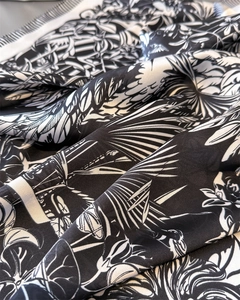 Detailed close-up of folded silk scarf featuring elegant black and white botanical leaf patterns