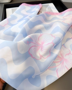 Détail d'un foulard en soie à vagues bleues avec des imprimés de fleurs d'hibiscus roses