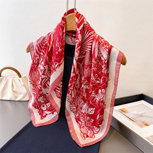 Elegant floral print silk-feel square scarf in red and white hanging on a wooden hanger