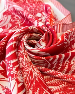 Macro view of luxurious red and white floral silk scarf with elegant spiral folding detail