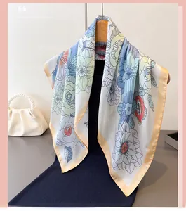 Detail view of a floral silk scarf with yellow edges draped over a wooden hanger