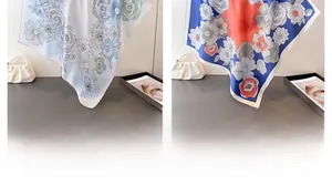 Detail view of floral print silk scarves in white and navy blue with smooth texture