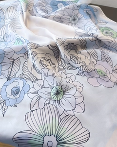 Detailed close-up of floral print silk scarf showing soft drape and satin texture
