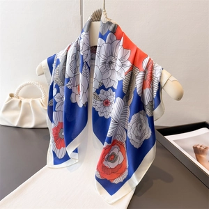 Royal blue floral silk scarf displayed on a white hanger with modern art pattern