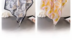 Vue détaillée de foulards en soie à fleurs noir et jaune avec texture satinée lisse