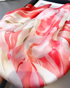 Gros plan d'un foulard en soie à motif floral montrant la texture satinée et l'ourlet
