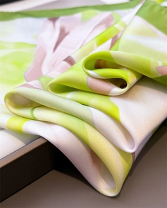 Vue détaillée d'un foulard en satin avec des blocs abstraits vert et rose et ourlet lisse