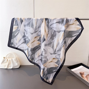 Détail d'un élégant foulard en soie imprimé floral avec bordures noires sur support
