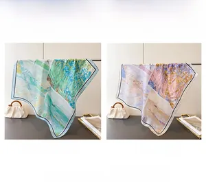Detail view of floral art print silk scarves in blue-green and beige color options