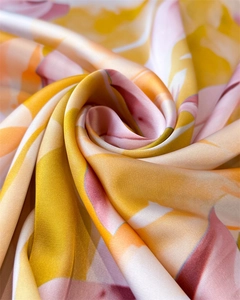 Détail de foulard en soie aux motifs floraux abstraits en jaune et rose vif