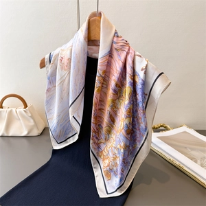 Floral oil painting print silk scarf elegantly styled on a wooden hanger with soft lighting
