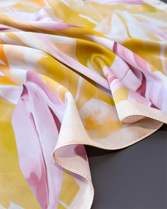 Détail d'un foulard en soie avec imprimé floral et bordure finement cousue