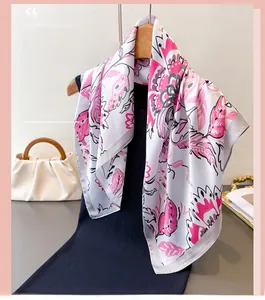 Detail of silk-like floral square scarf with pink flower prints on a blue blazer