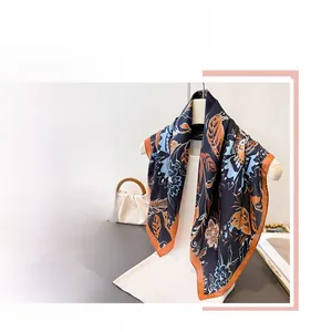 Detailed close-up showing the vintage floral pattern and orange stitched edges of the scarf