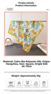 Detail of floral printed satin silk scarf featuring vibrant orange and yellow blooms