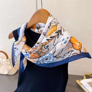 Detail of vintage floral faux silk scarf tied on navy top showing texture and print