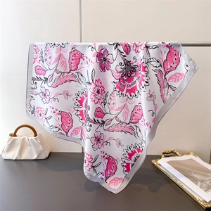 Detailed view of floral silk scarf featuring elegant pink petal prints and premium edging