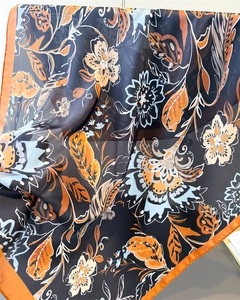 Detail of floral printed silk scarf showing soft drape and orange rolled edge finish