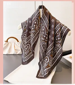 Detailed close-up of dark brown paisley silk scarf with glossy texture and fine print