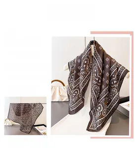 Close-up of vintage brown silk scarf featuring white paisley patterns and soft texture