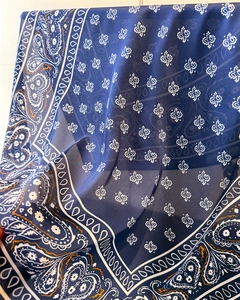 Macro detail of navy blue paisley silk scarf with white heart patterns on soft fabric