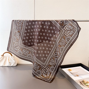 Elegant dark brown paisley silk scarf with heart patterns hanging in a French style setting