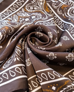 Macro detail of silk scarf showing paisley pattern and soft satin texture in rose shape