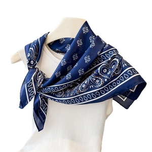 Navy blue paisley printed silk square scarf styled on a white top for an elegant look