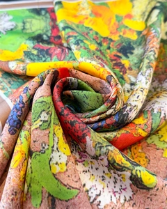 Detailed macro shot of floral silk scarf featuring vibrant oil painting artistic patterns