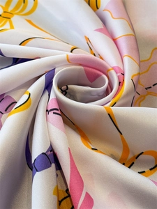 Close-up of a satin scarf with colorful geometric patterns and elegant silk-like texture