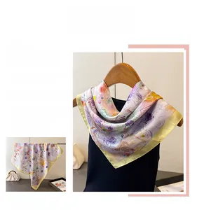 Dettaglio di un foulard quadrato in finta seta con stampa floreale e bordi gialli