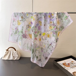 Dettaglio di un foulard in seta con stampe floreali e rifiniture eleganti con bordo rosa