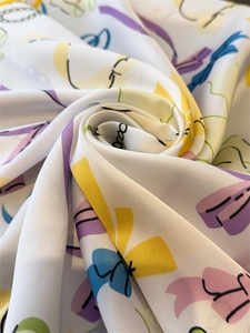 Detail of silk-like square scarf featuring colorful abstract print and satin luster