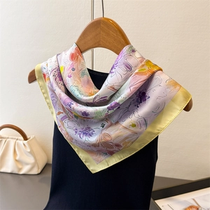 Elegante foulard quadrato in raso a fiori su un appendiabiti con un gilet nero chic