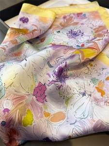 Dettaglio della texture in raso con motivo floreale colorato sulla sciarpa di seta