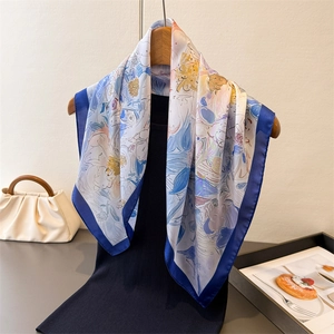 Foulard artistico in seta a fiori blu reale e giallo, drappeggiato su una gruccia